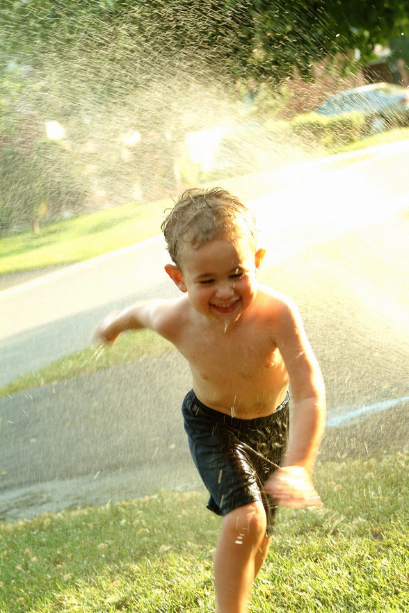 kid running in sprinkler