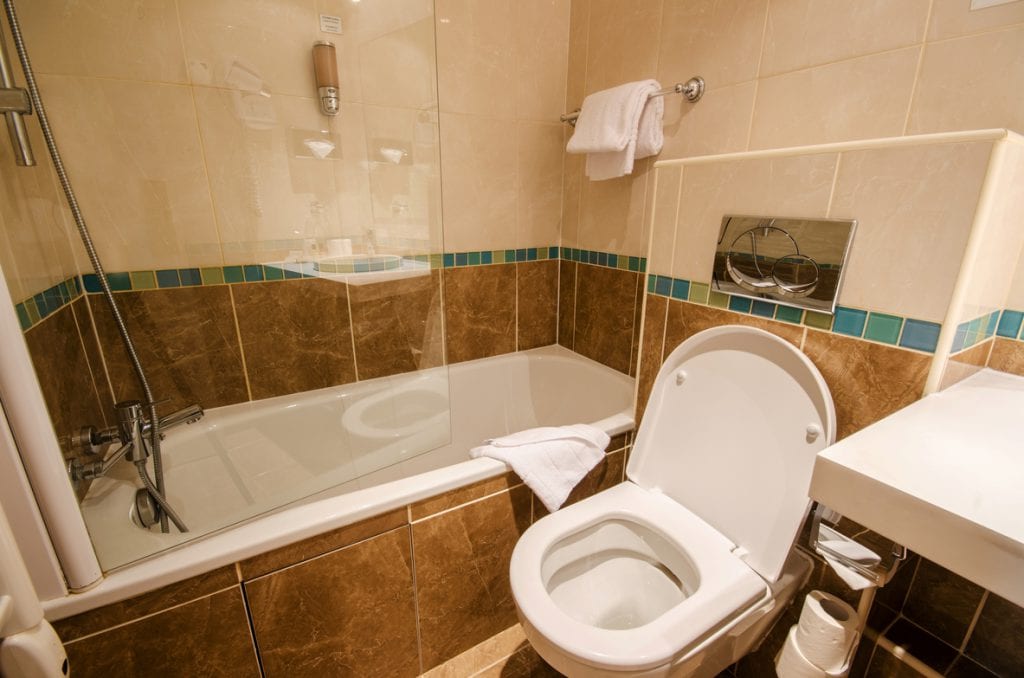 A toilet and tub in a modern bathroom.