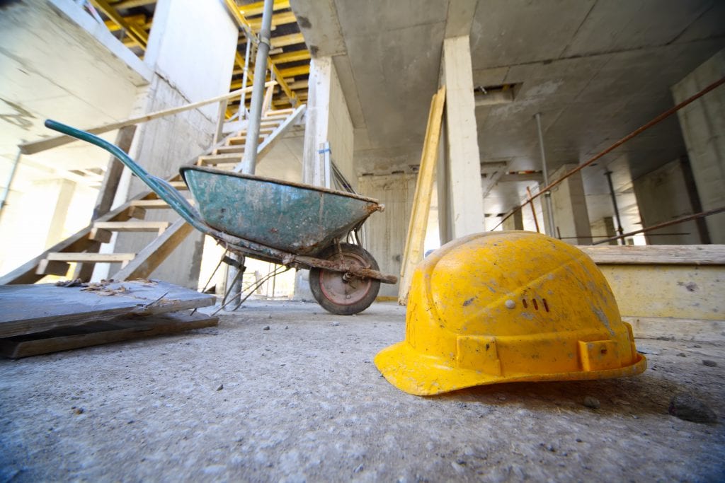 Yellow hard hats and small cart on concrete floor
